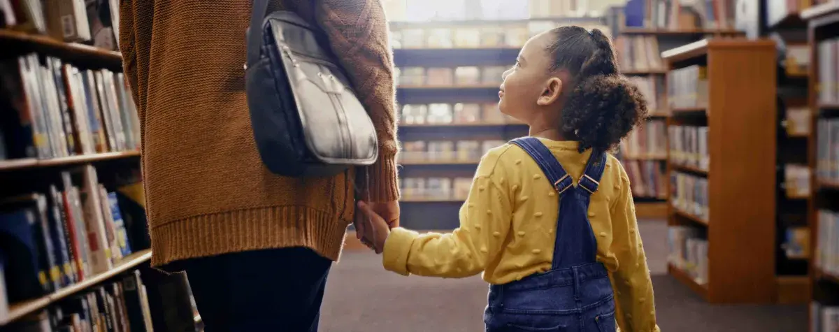 A child looks up hopefully inside of a library
